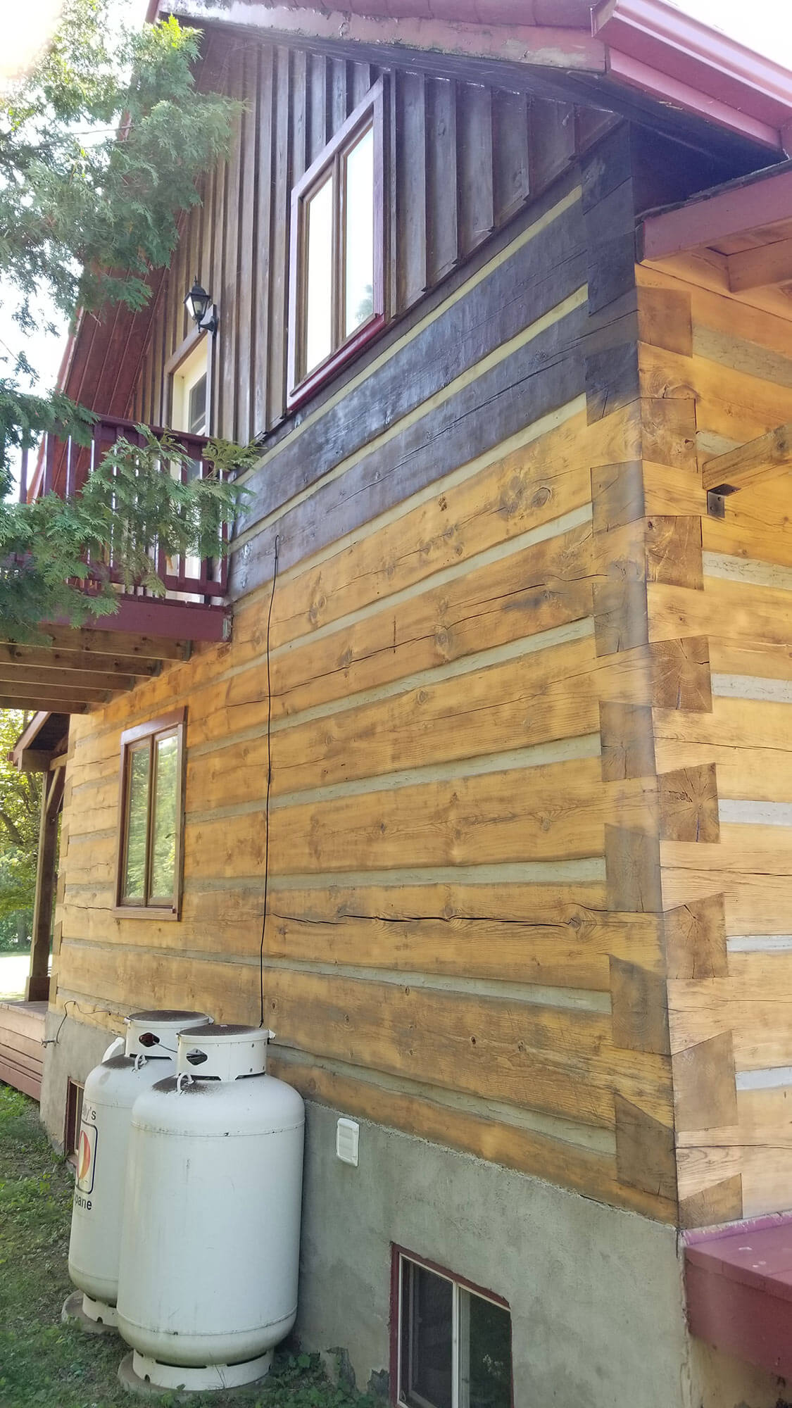 Log cabin exterior partially stripped during restoration