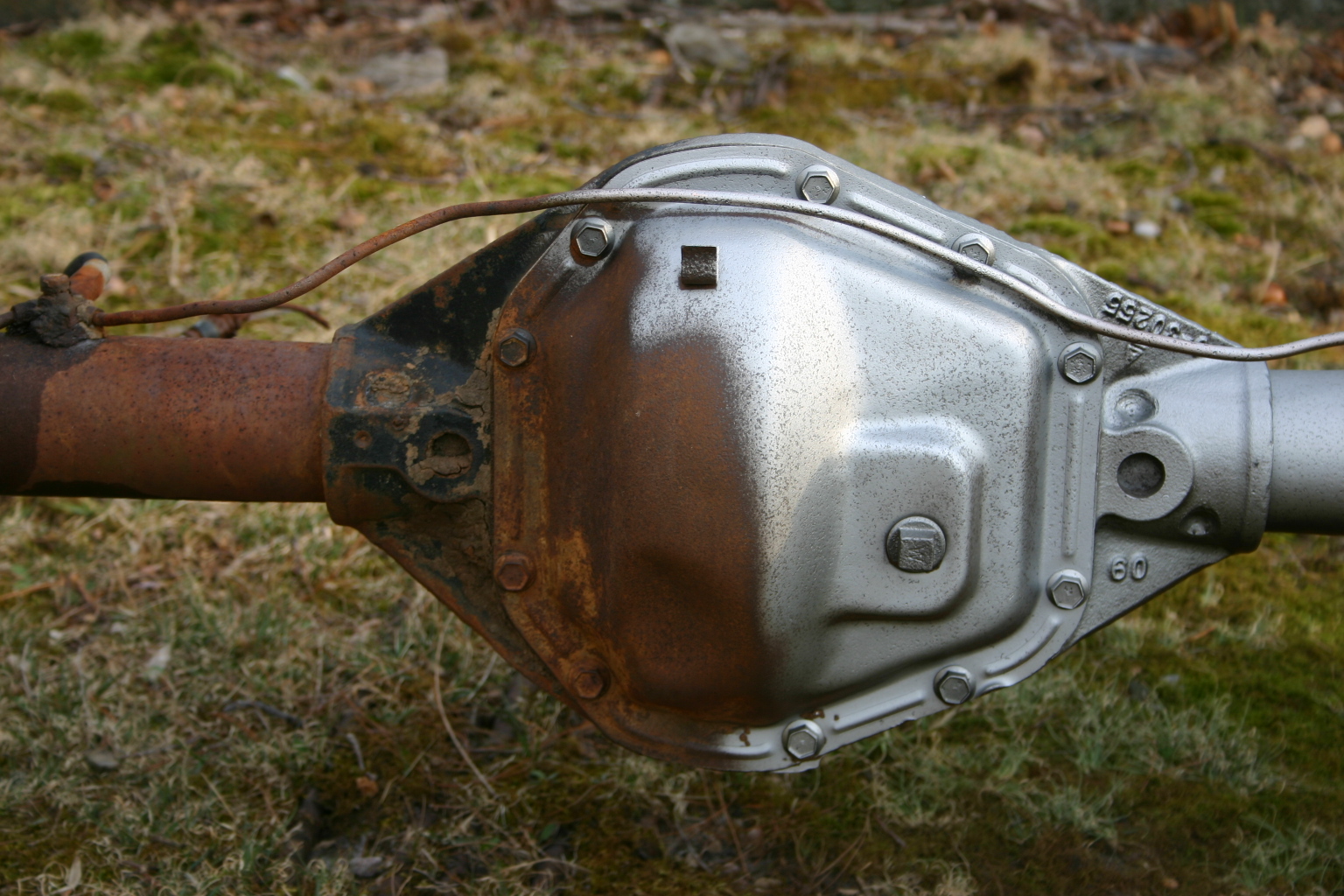 Rear axle housing, half rusted and half blasted clean